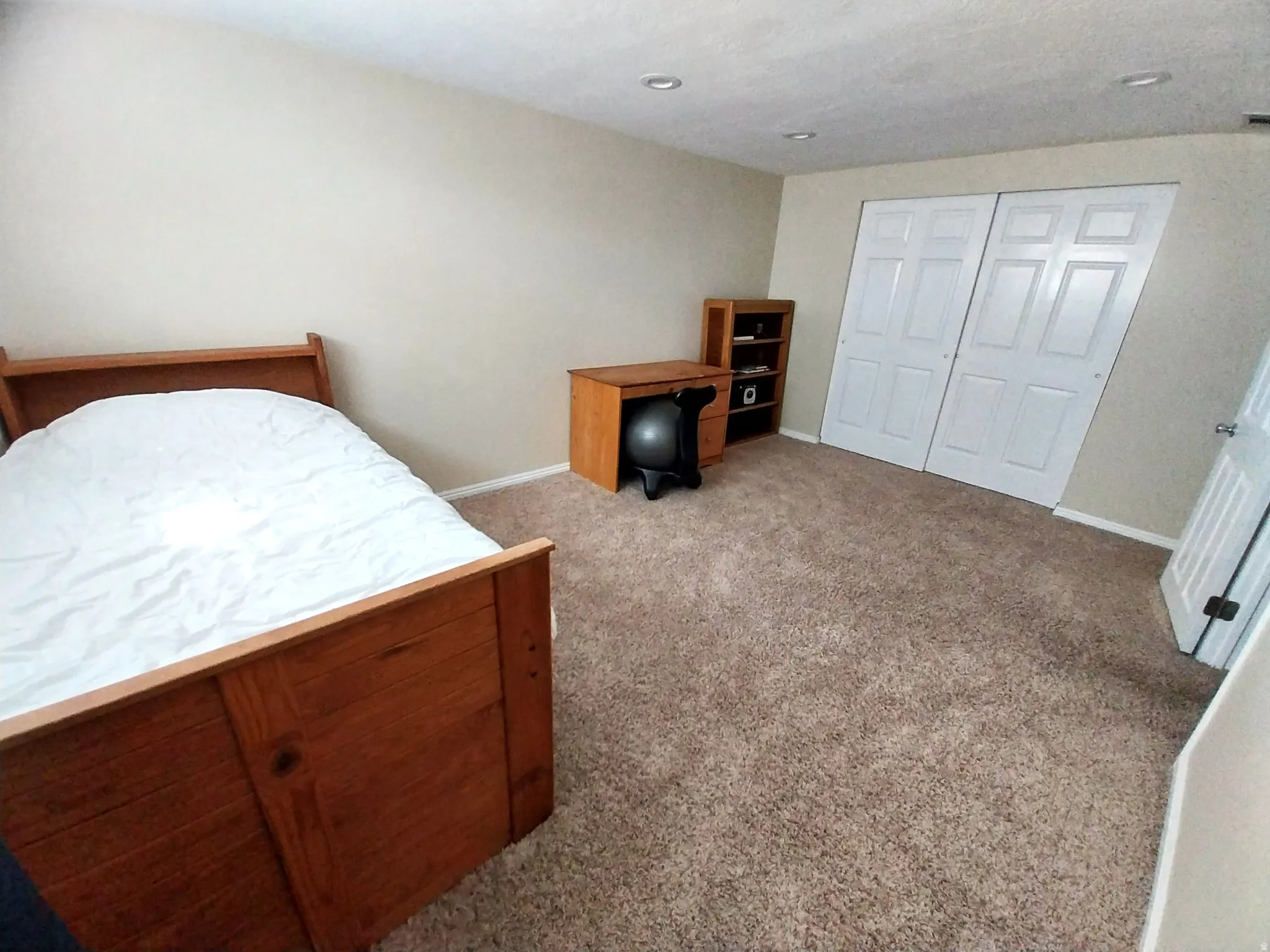 Bedroom featuring light carpet and a closet