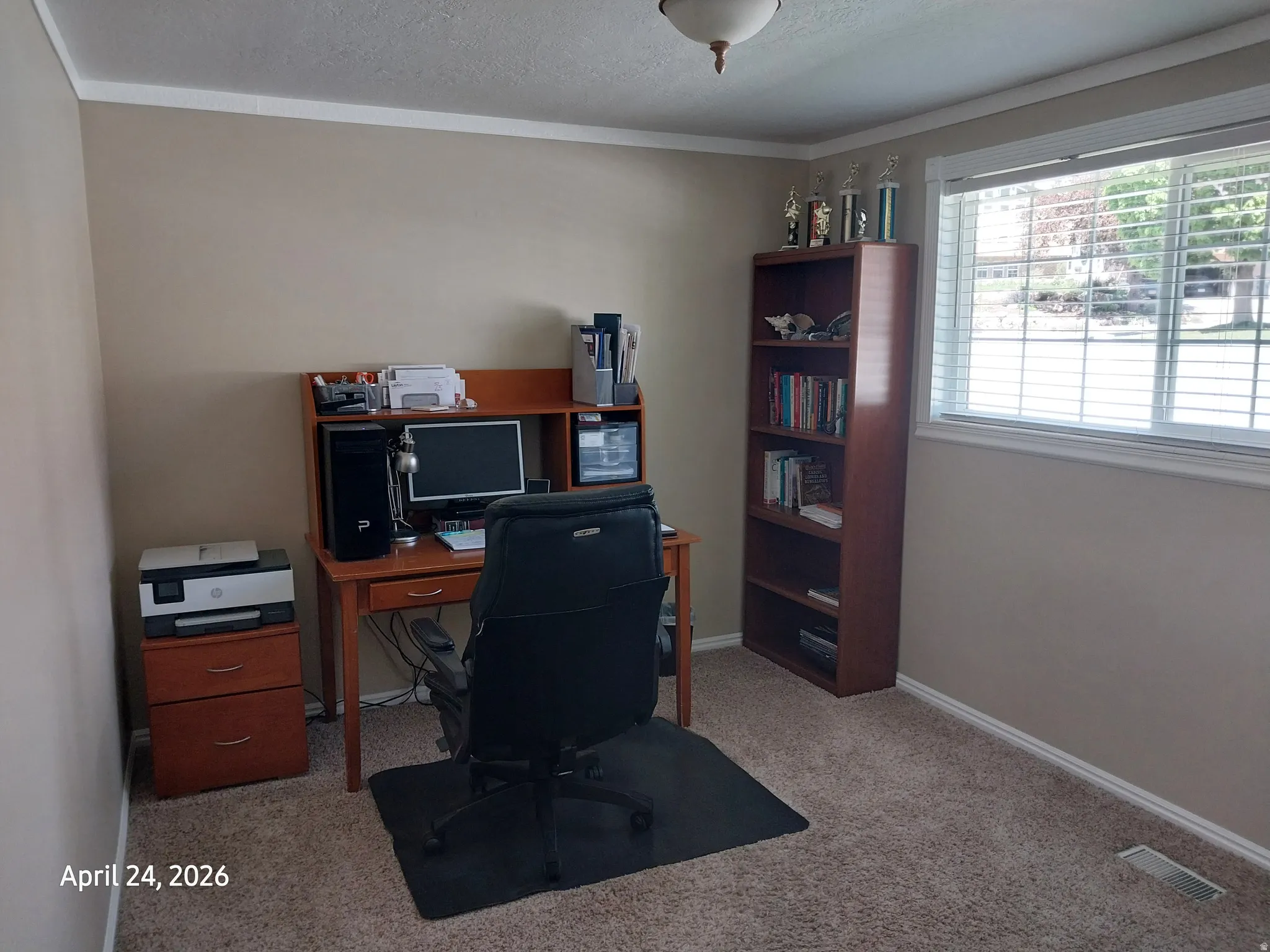 Office area featuring light carpet and a textured ceiling