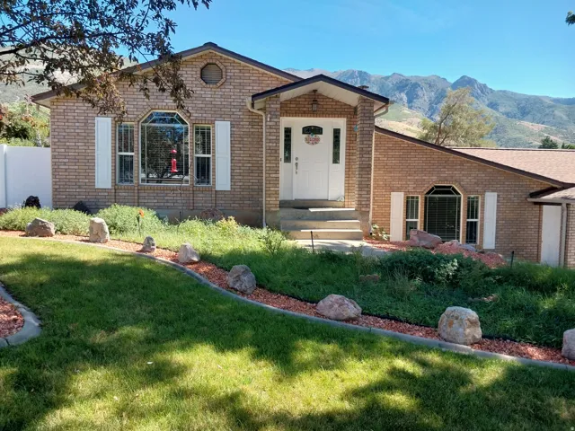 Brick exterior with white decorative shutters, a covered entry, and a multi-pane front door