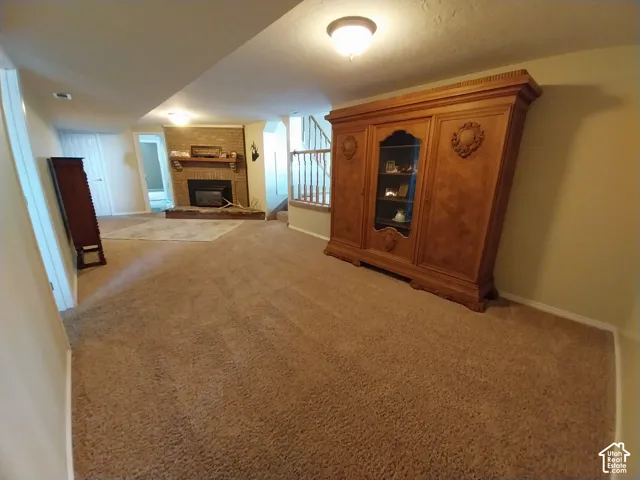 Potential cinema area, featuring light carpet and a fireplace
