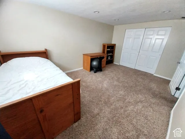Bedroom featuring light carpet and a closet