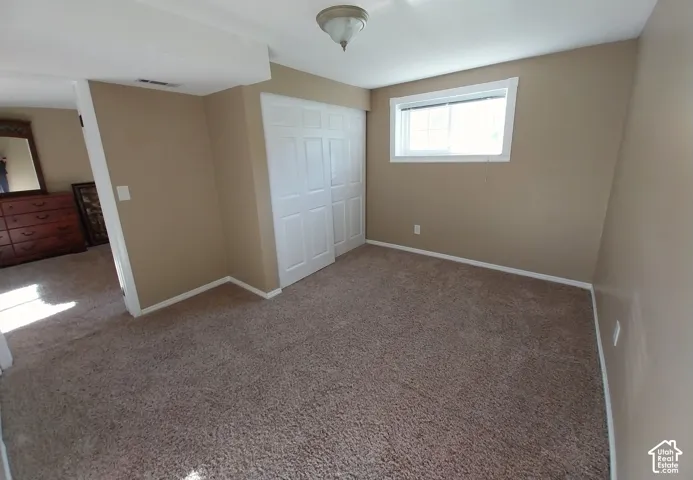 Unfurnished bedroom with carpet flooring and a closet