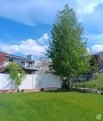 Fenced backyard featuring Red wood raised beds and a mature Quaking Aspen