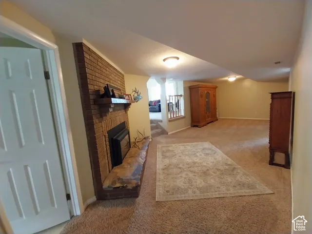 Living area with light carpet and a brick fireplace