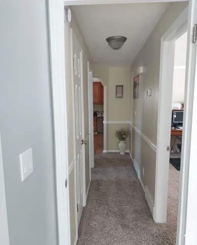 Hall with light colored carpet and arched walkways