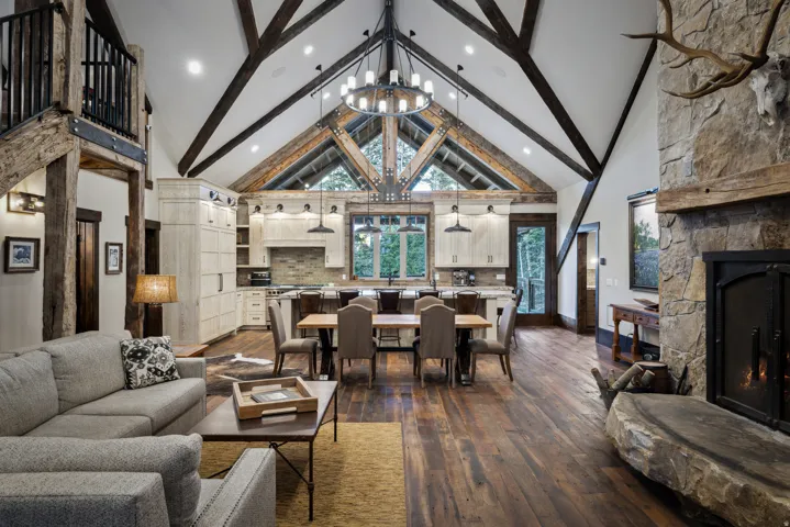 Soaring vaulted ceiling with exposed timber beams and skylights illuminates this open-concept living space