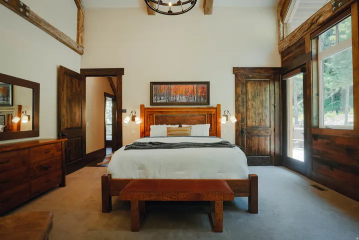 Vaulted ceiling with exposed wood beams and chandelier