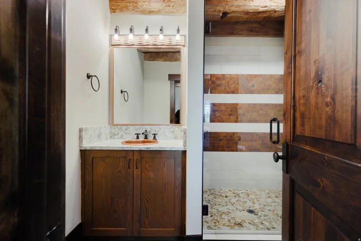 Bathroom vanity with a wood-finish cabinet, stone countertop, and vessel sink