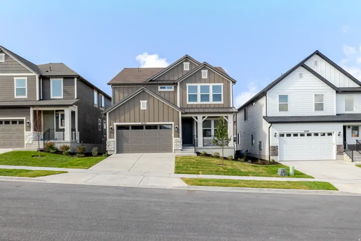 Modern exterior featuring a covered porch, two-car garage, and concrete driveway