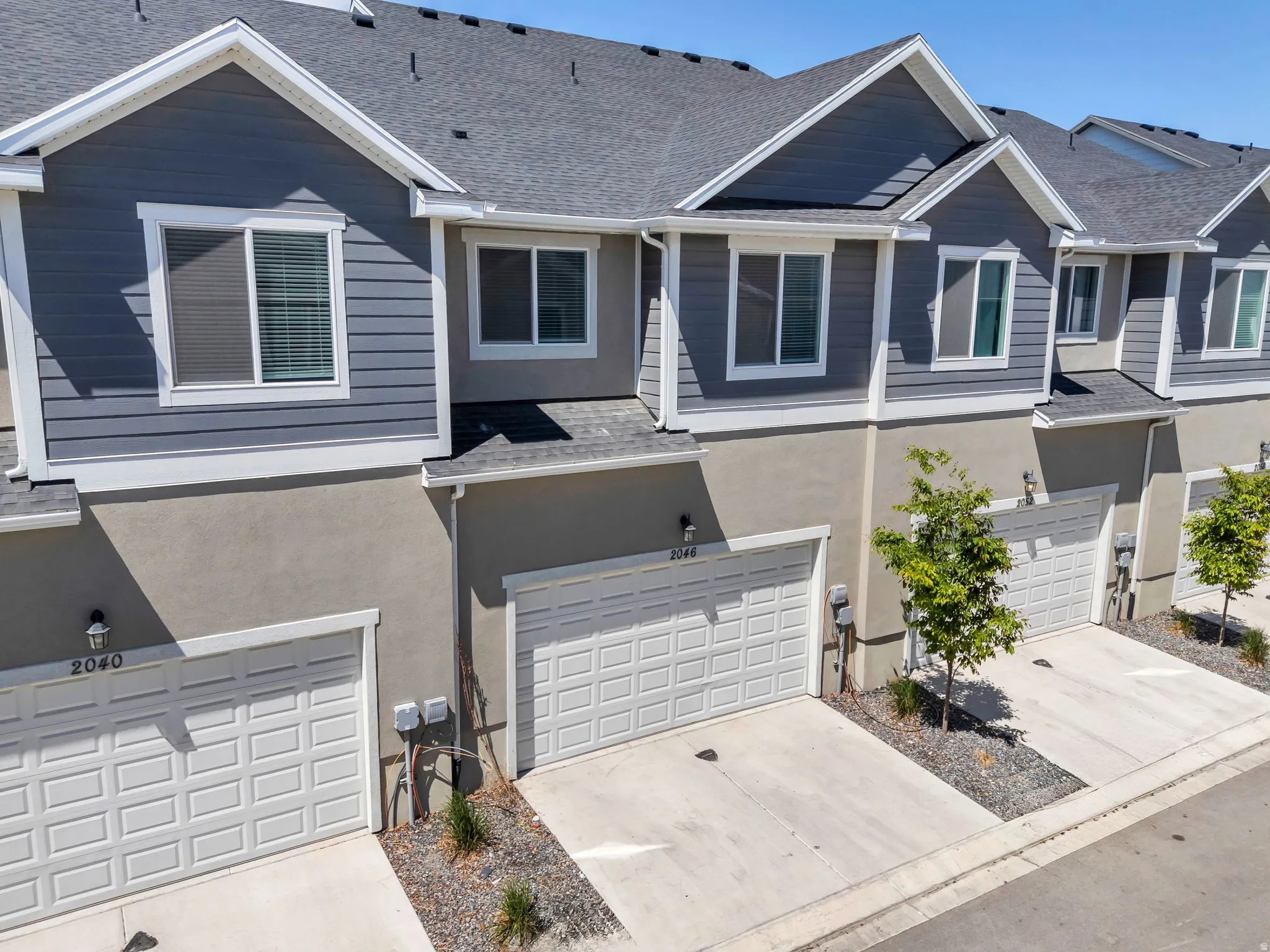 Contemporary townhome exterior featuring gray horizontal siding and stucco accents