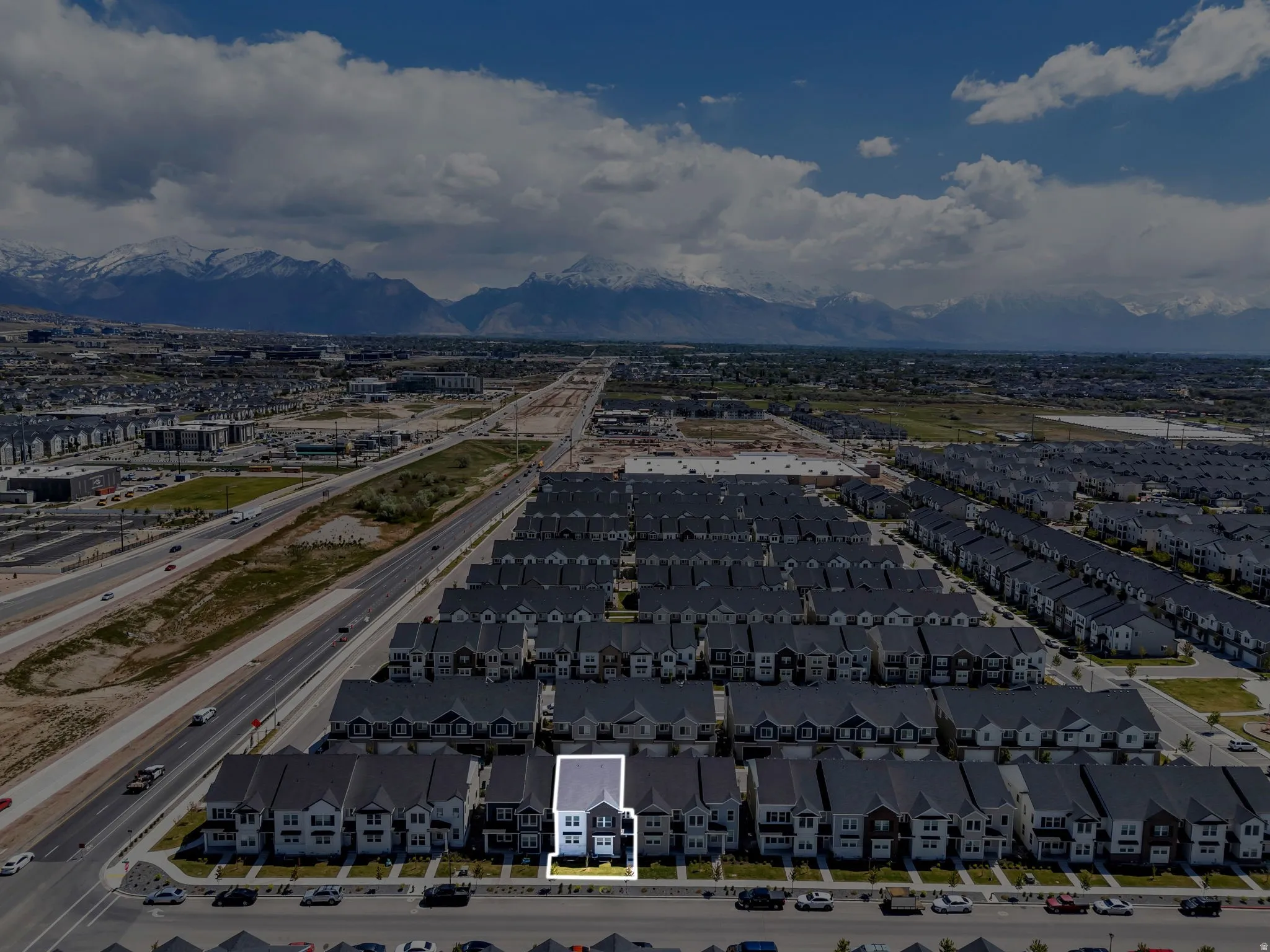 Aerial depiction of a neighborhood with a prominent mountain range backdrop
