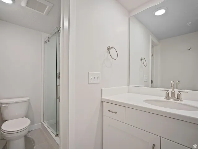 Bathroom featuring a white vanity with an undermount sink, brushed nickel faucet, large wall-mounted mirror, and white cabinetry