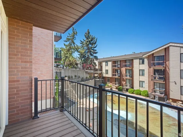 Private balcony featuring composite wood decking and black metal railing
