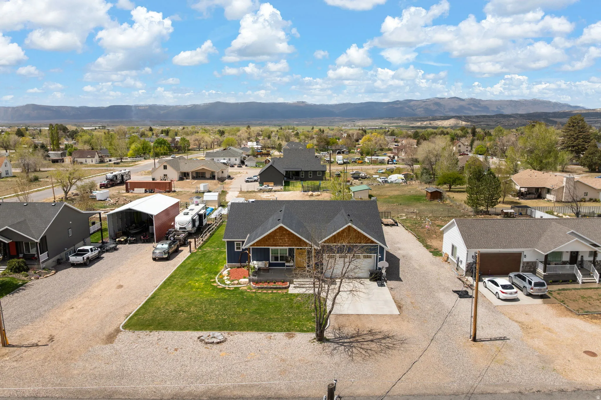 Ranch-style exterior with wood shake accents, attached garage, and a gravel driveway