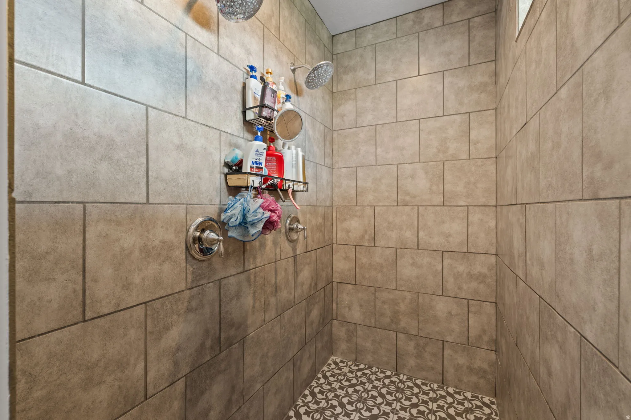 Primary Bedroom with en-suite, tiled shower enclosure featuring dual showerheads and a decorative mosaic tile floor