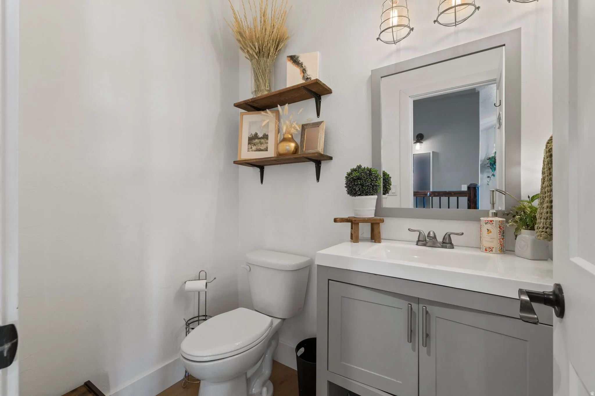 Modern bathroom featuring a single vanity with grey cabinetry, a white countertop, and a rectangular mirror