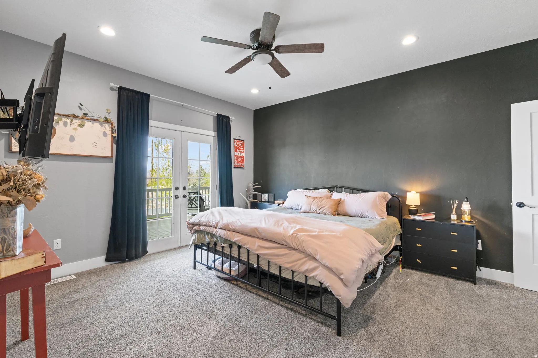 Primary Bedroom with en-suite, carpeted interior space featuring French doors with dark curtains, leading to an exterior oversized deck