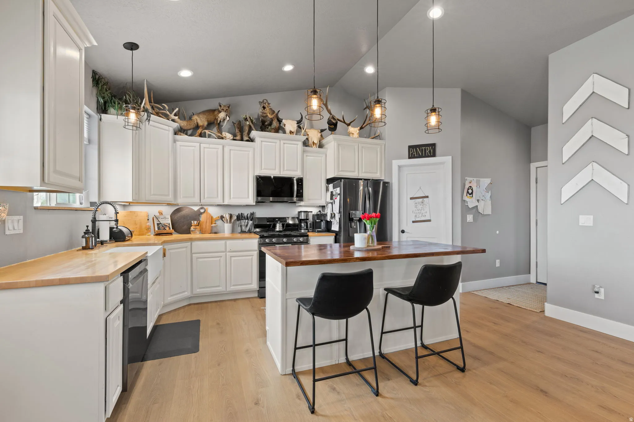 Kitchen featuring light wood-finish flooring, white cabinetry, a wood-finish countertop, and a center island with a wood-finish top