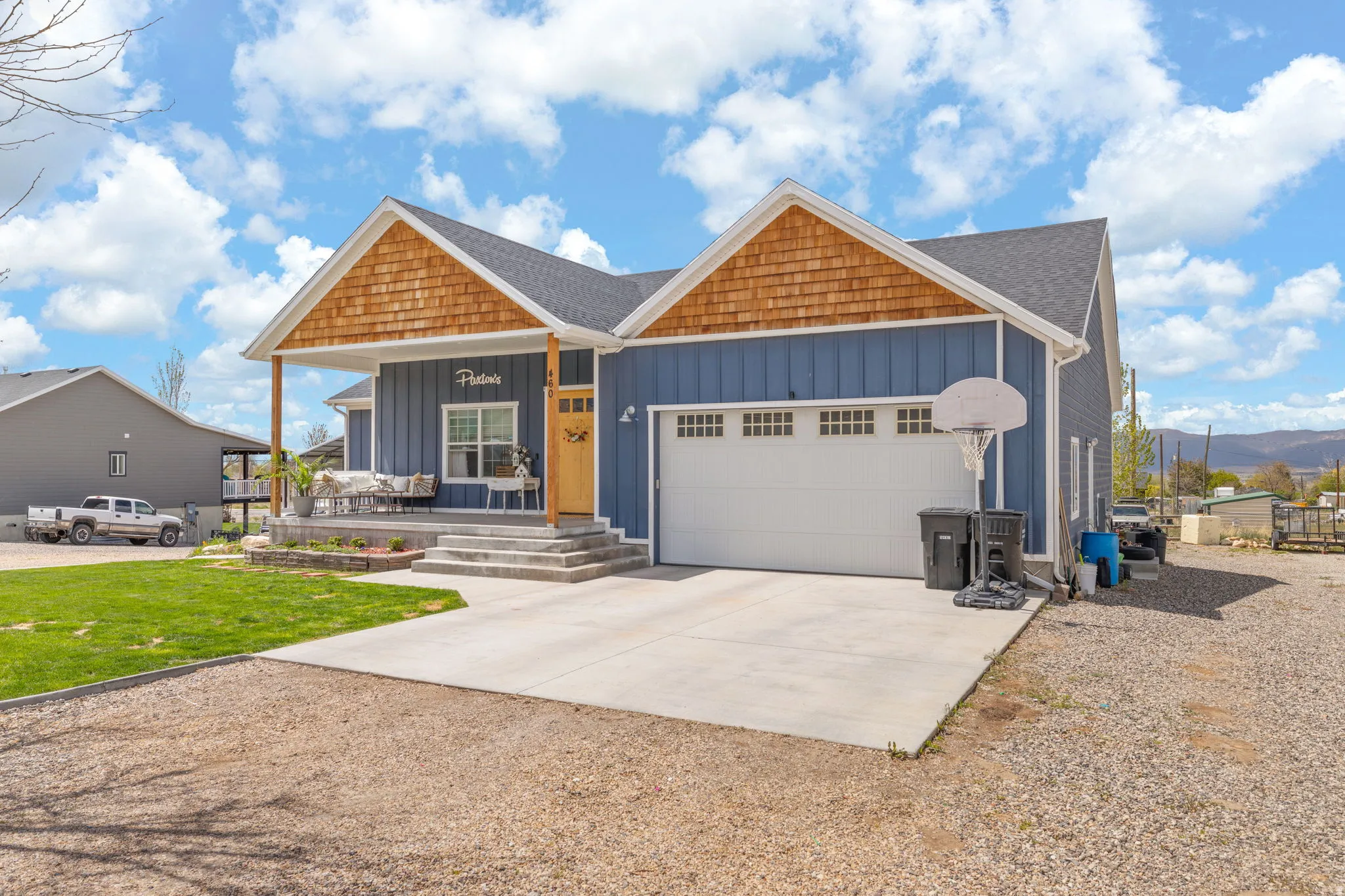Craftsman-style home featuring blue vertical siding and cedar shake gables