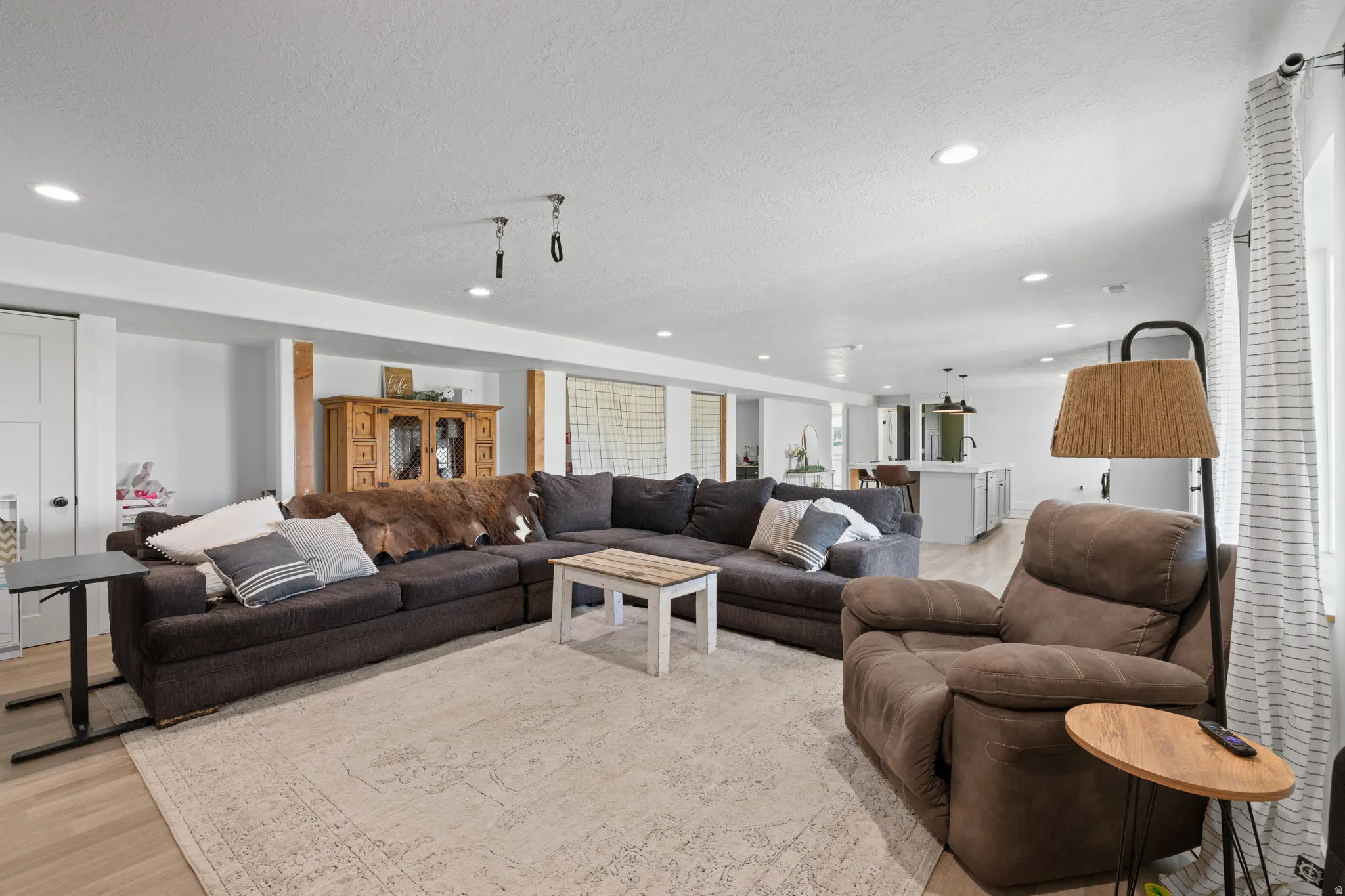 Basement ADU, spacious open-concept living area featuring recessed lighting, wood-finish flooring, and a neutral color palette