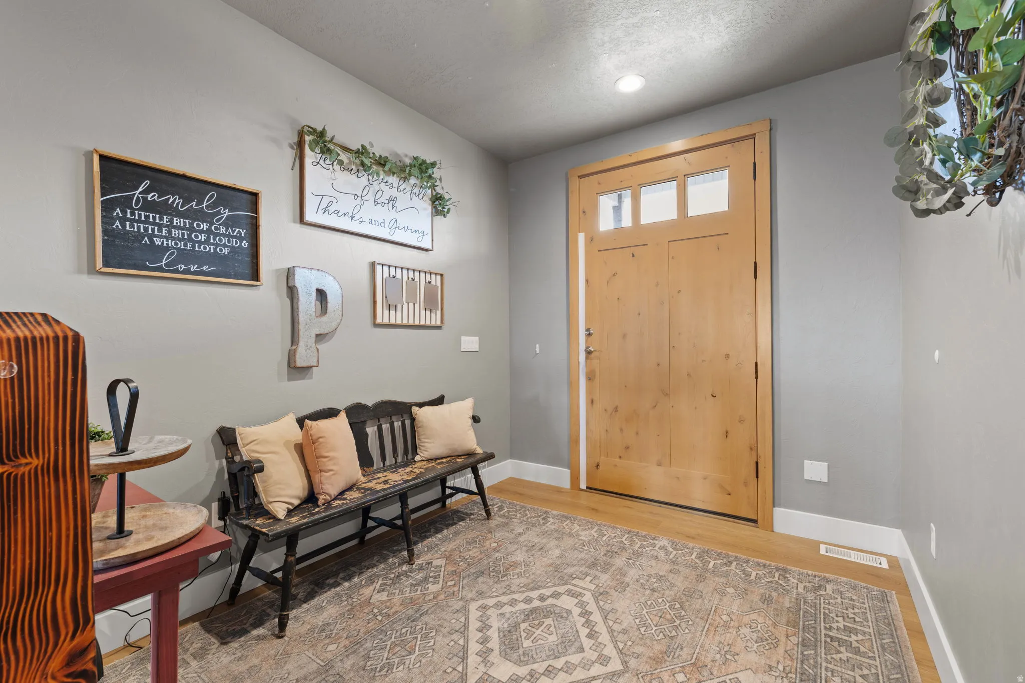 Natural oversized wood-finish entry door with upper window panes