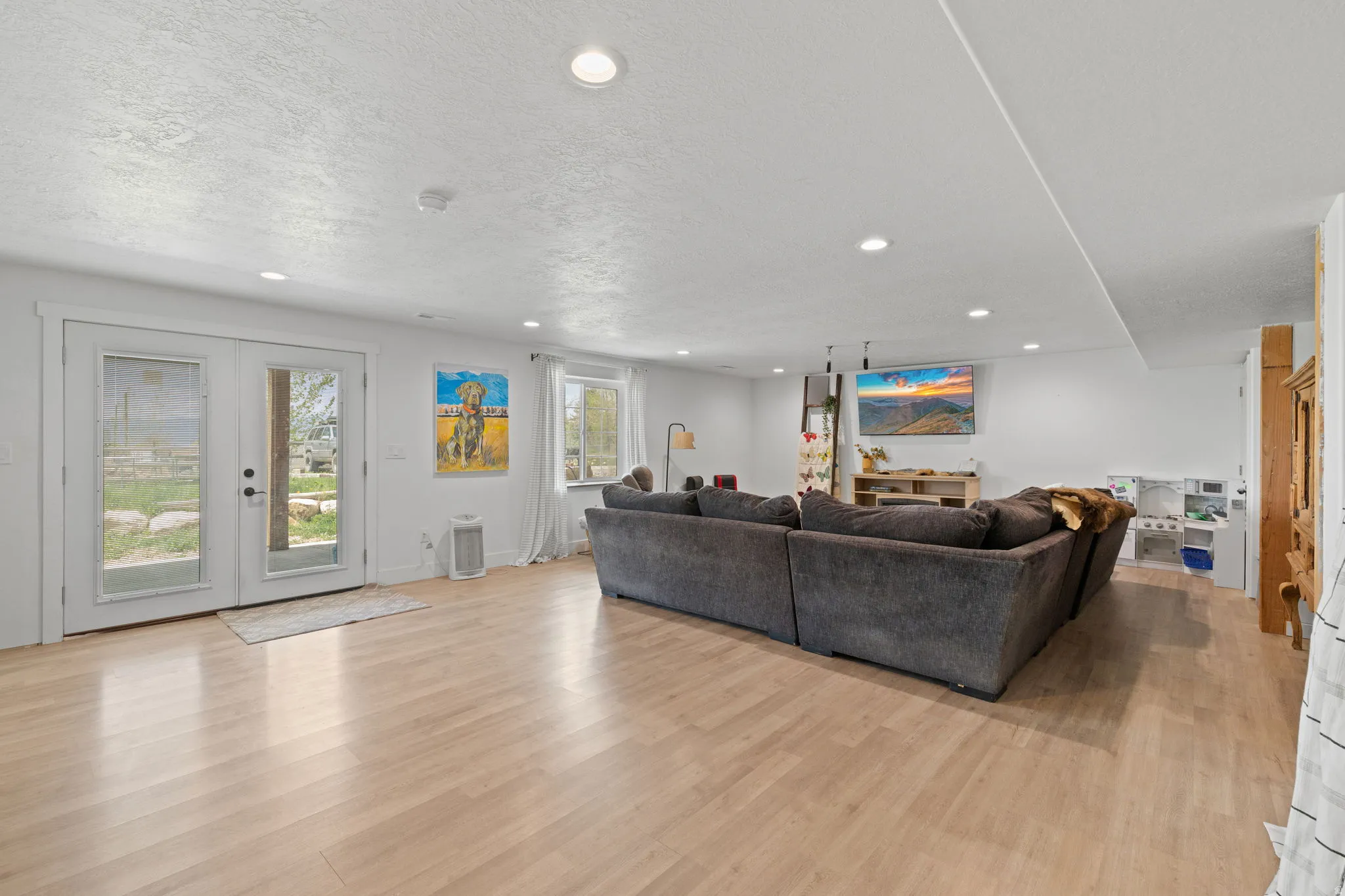 Basement ADU, spacious room featuring light wood-finish flooring, recessed lighting, and white walls