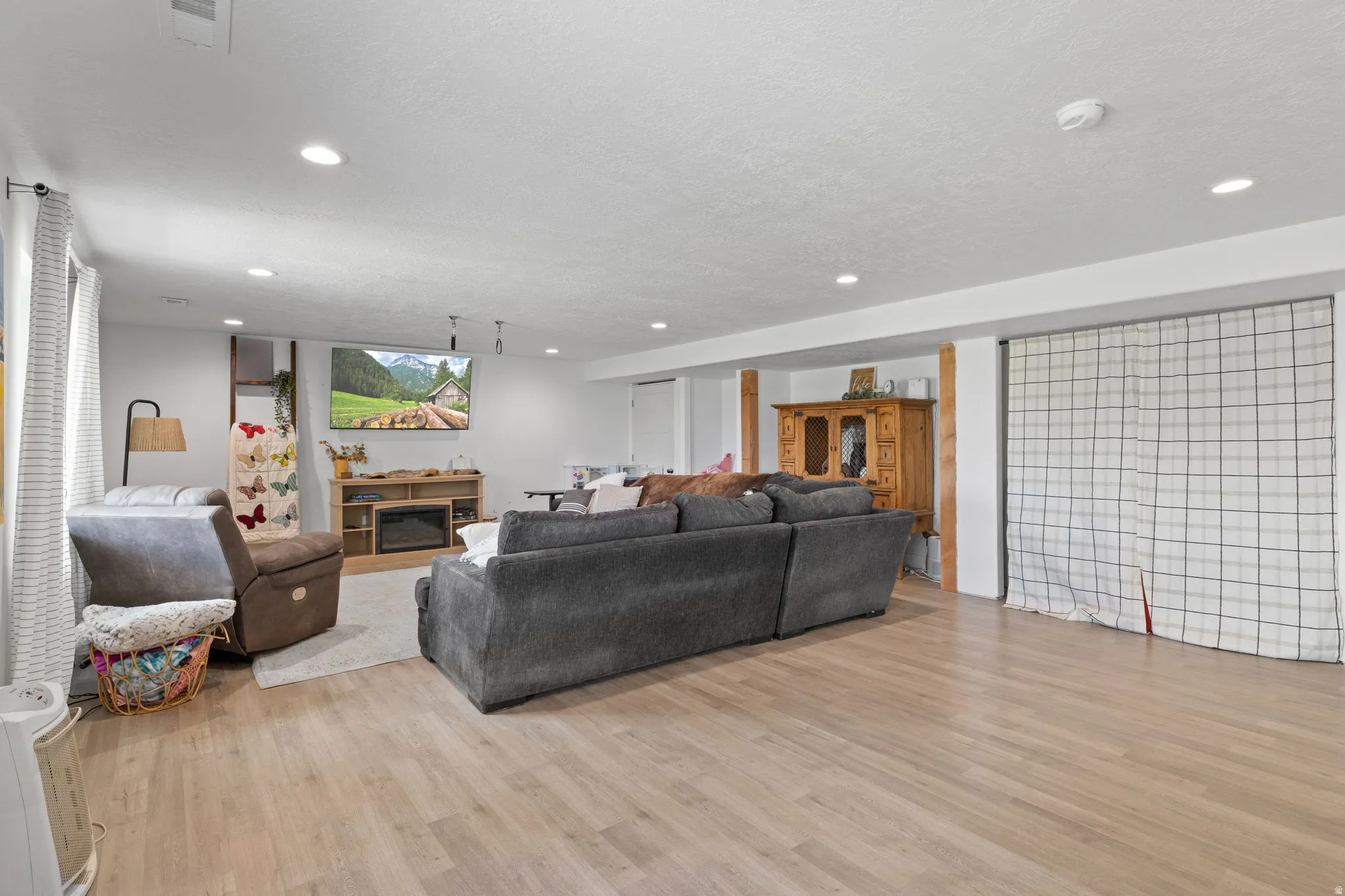 Basement ADU, spacious room featuring light wood-finish flooring, recessed lighting, and white walls