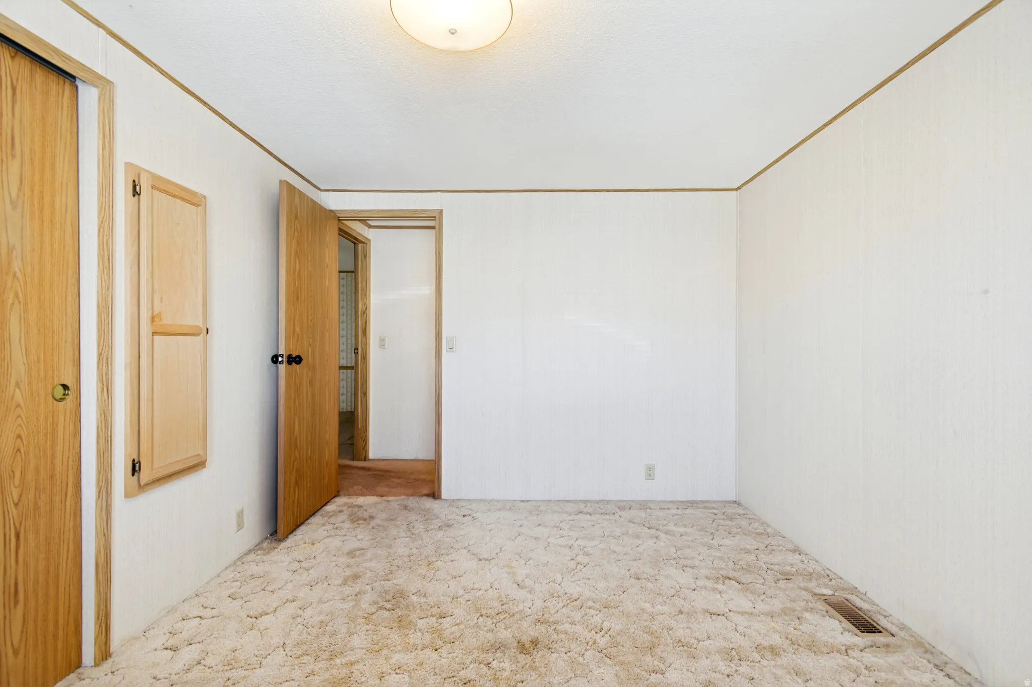 Spare room featuring light carpet and crown molding
