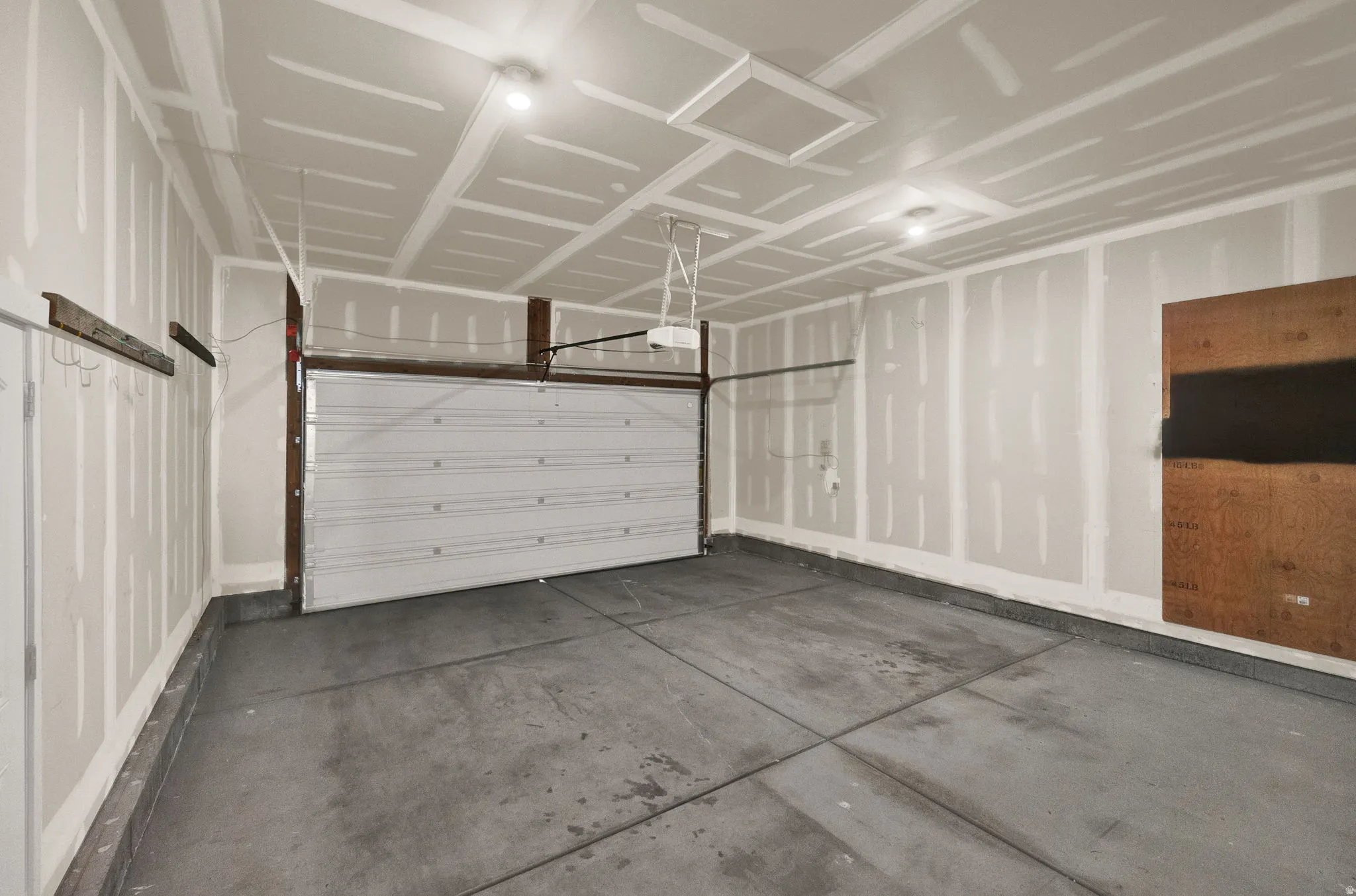 Spacious two-car garage with a concrete floor and a white panel garage door