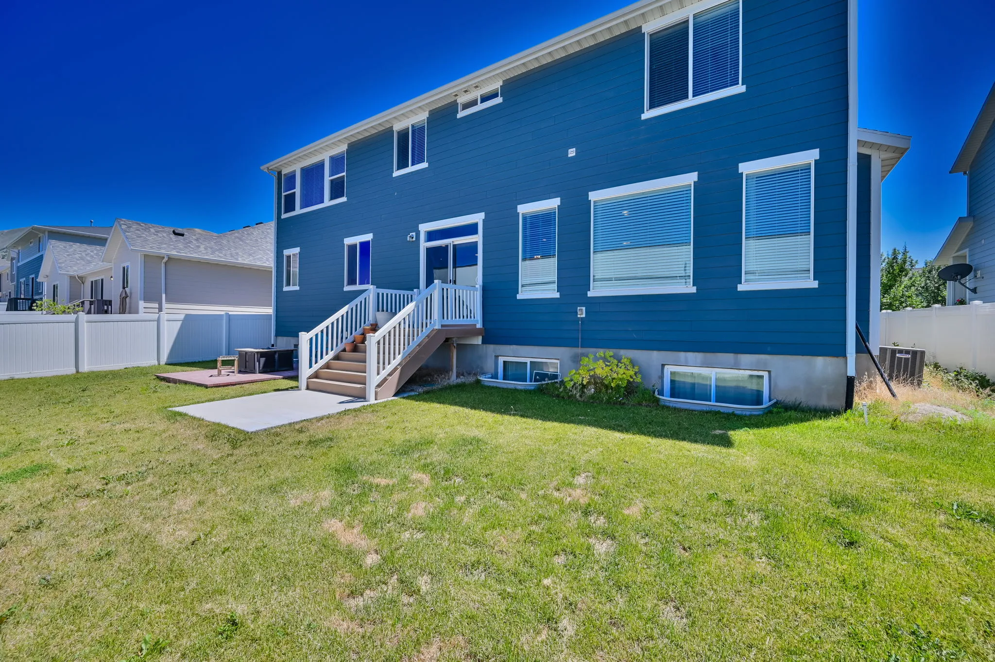 Rear exterior featuring blue siding, white trim, and multiple windows