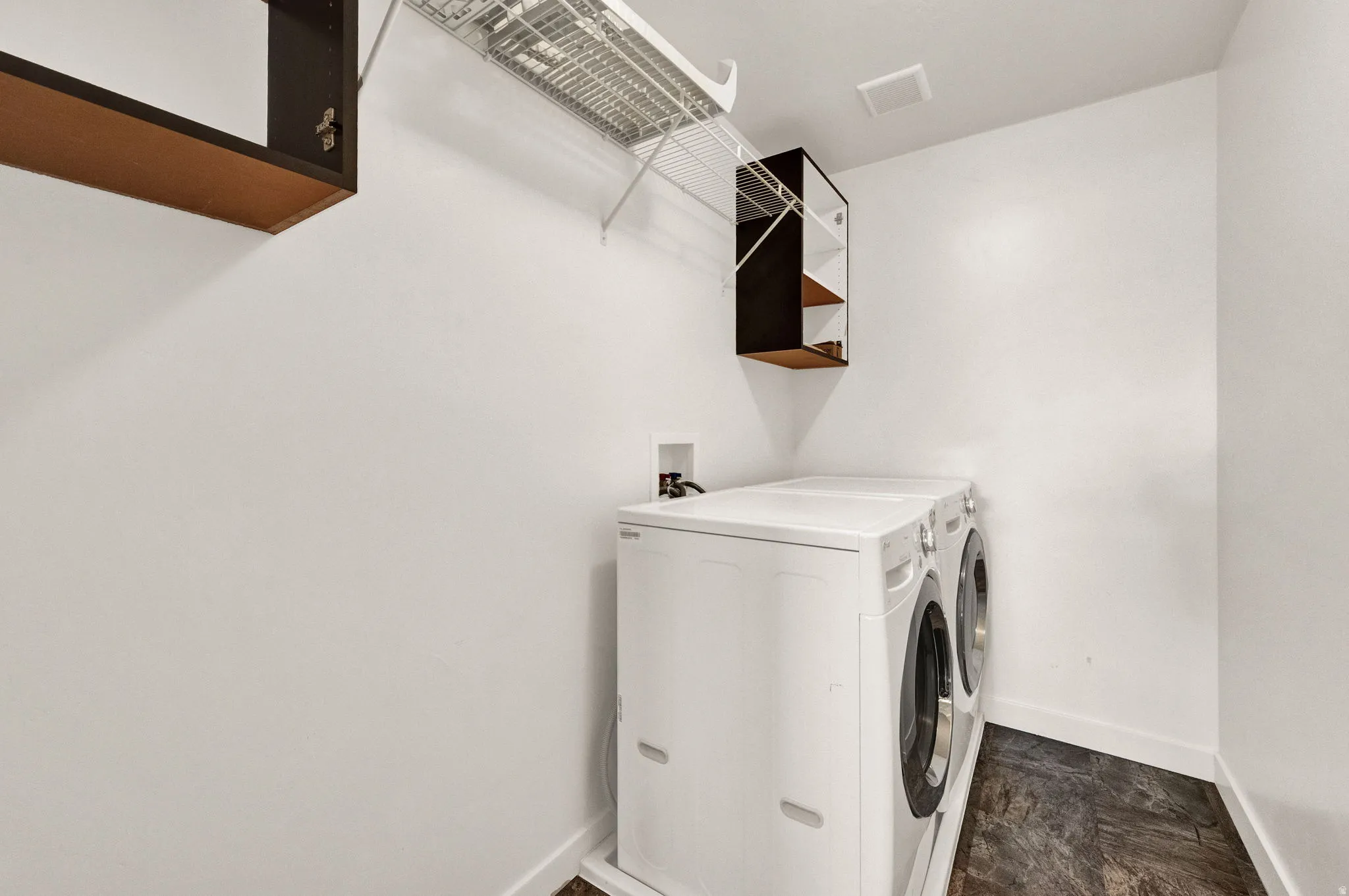 Dedicated laundry area featuring a white front-load washing machine and dryer