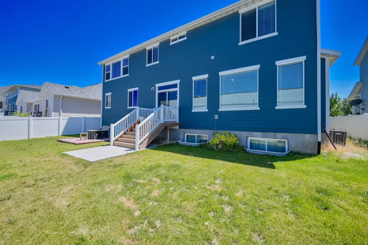 Blue siding exterior with white trim windows and a white vinyl fence