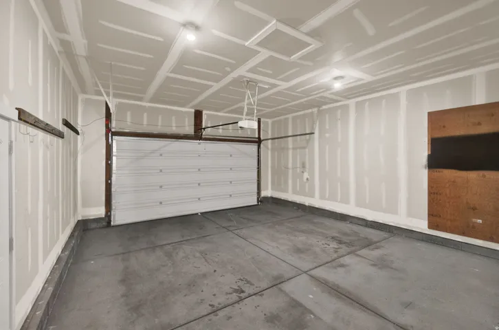 Spacious two-car garage with a concrete floor and a white panel garage door