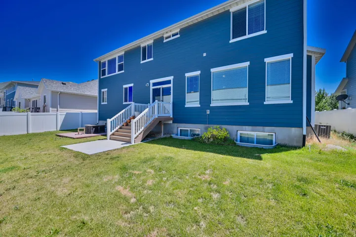 Rear exterior featuring blue siding, white trim, and multiple windows