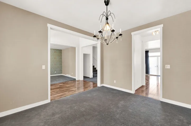 Central room featuring a decorative chandelier and dark gray carpeting