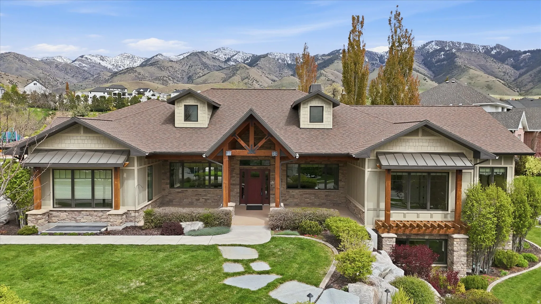 Craftsman-style residence featuring a stone and siding exterior with dark-framed windows
