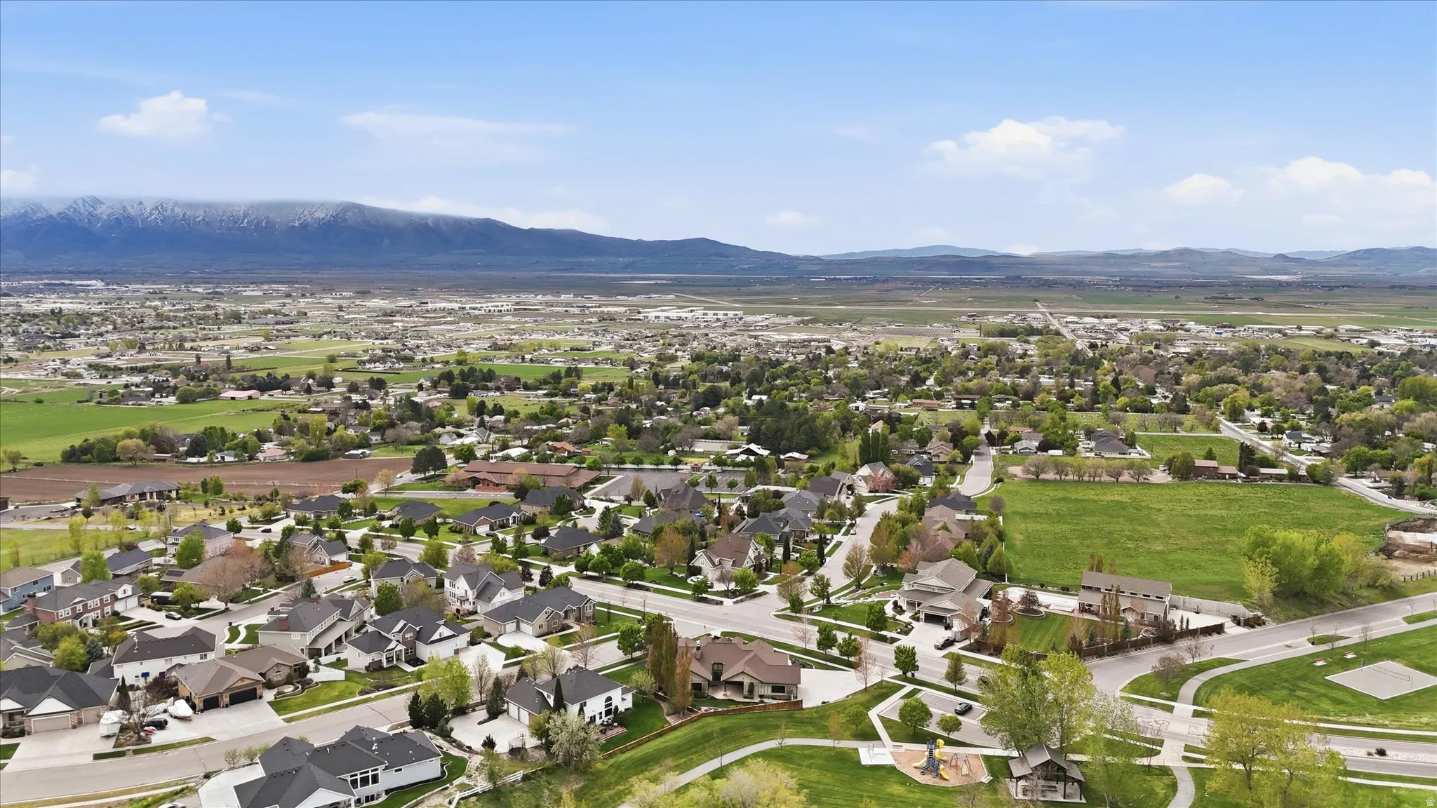 Expansive residential area featuring numerous single-family homes with diverse architectural styles, mature trees, and manicured green spaces