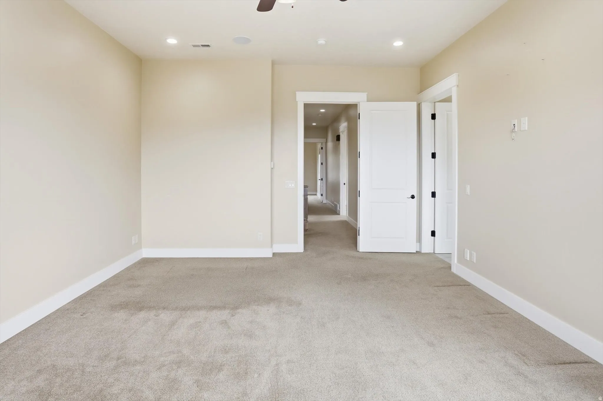 Spacious room featuring neutral carpet flooring and white baseboards