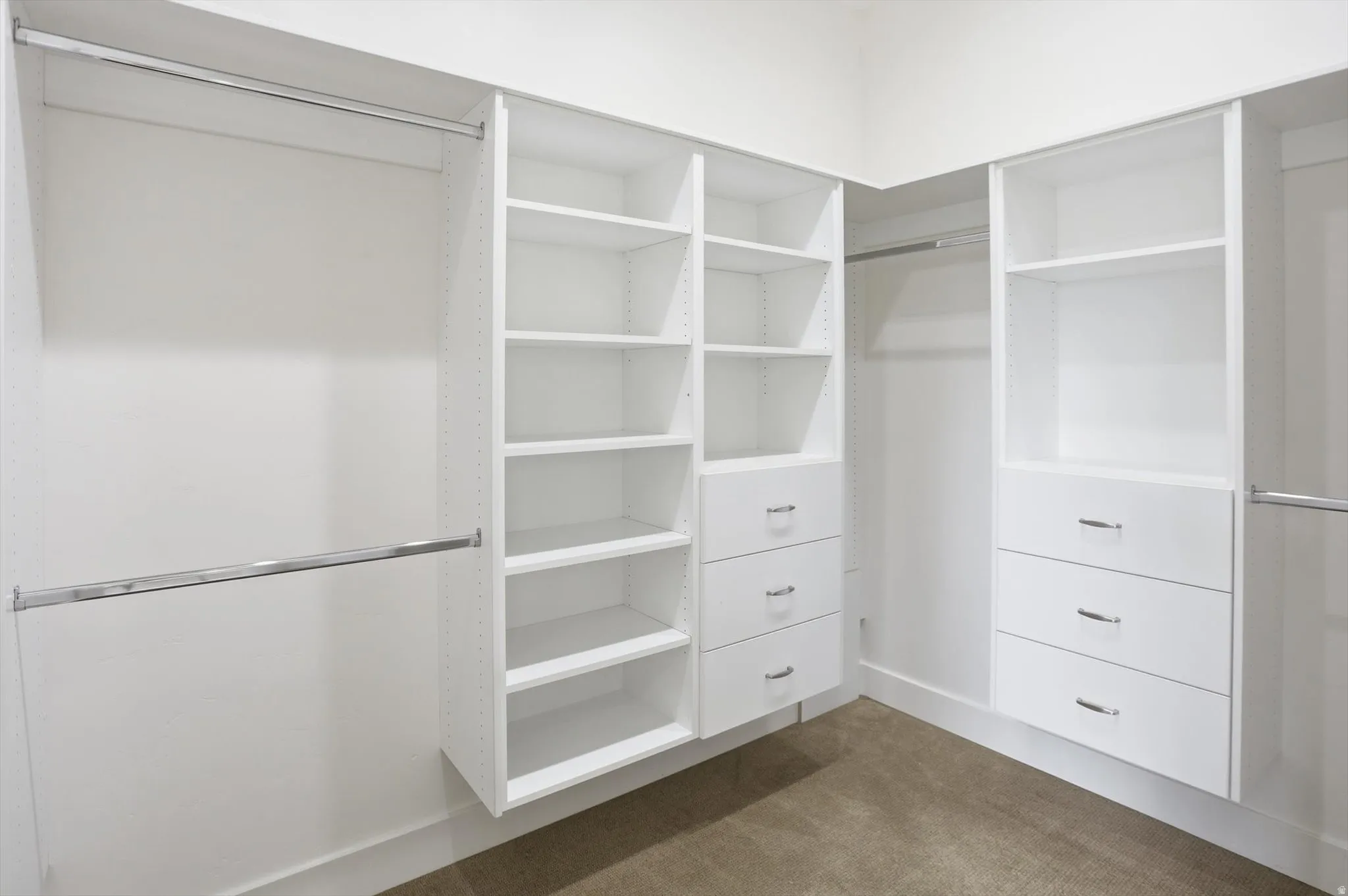 Walk-in closet featuring custom white cabinetry with integrated shelving and multiple drawer units