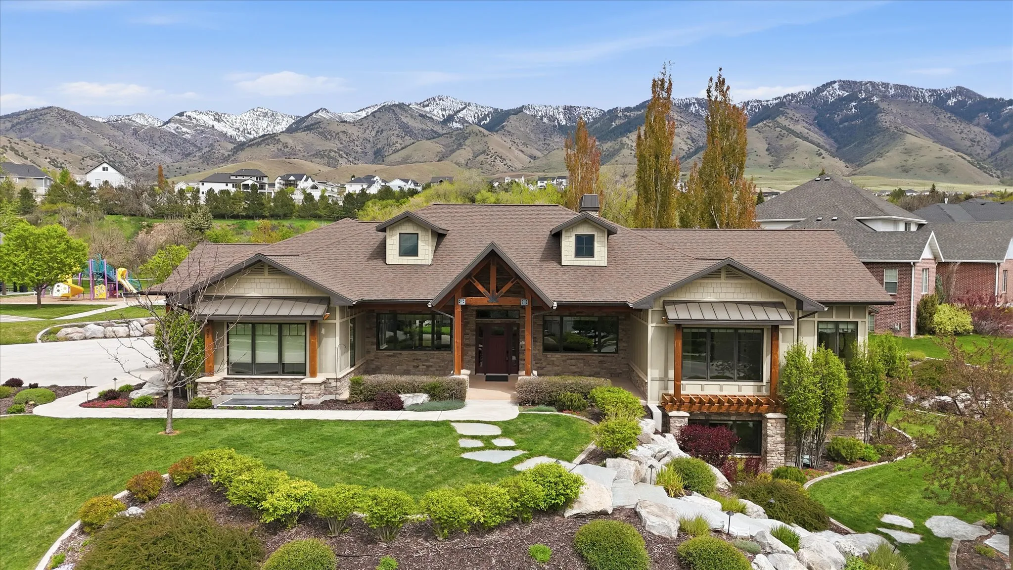 Craftsman-style residence featuring a prominent exposed timber entryway and stone accents