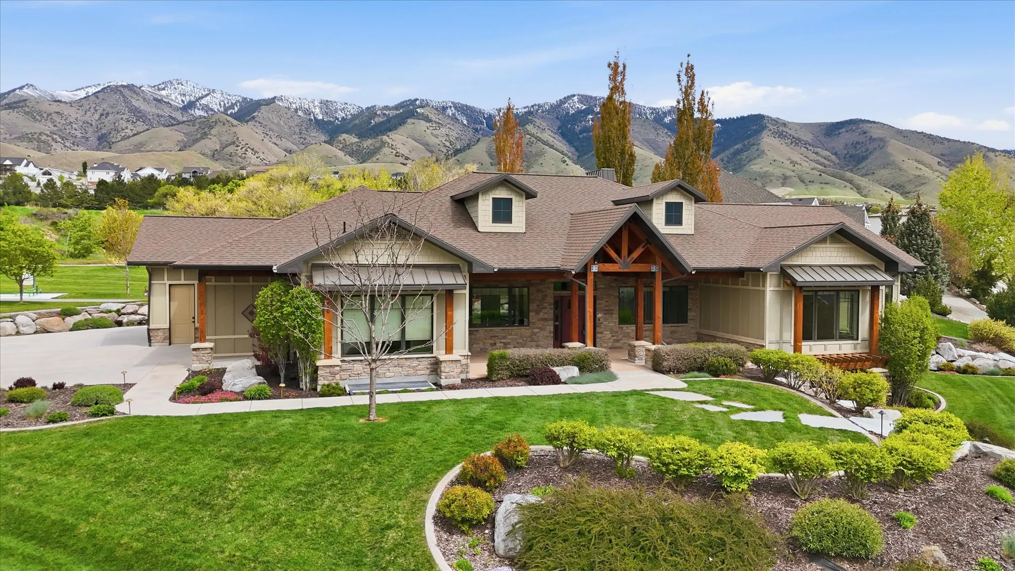 Craftsman-style residence featuring a stone and siding exterior with a prominent timber-framed entry