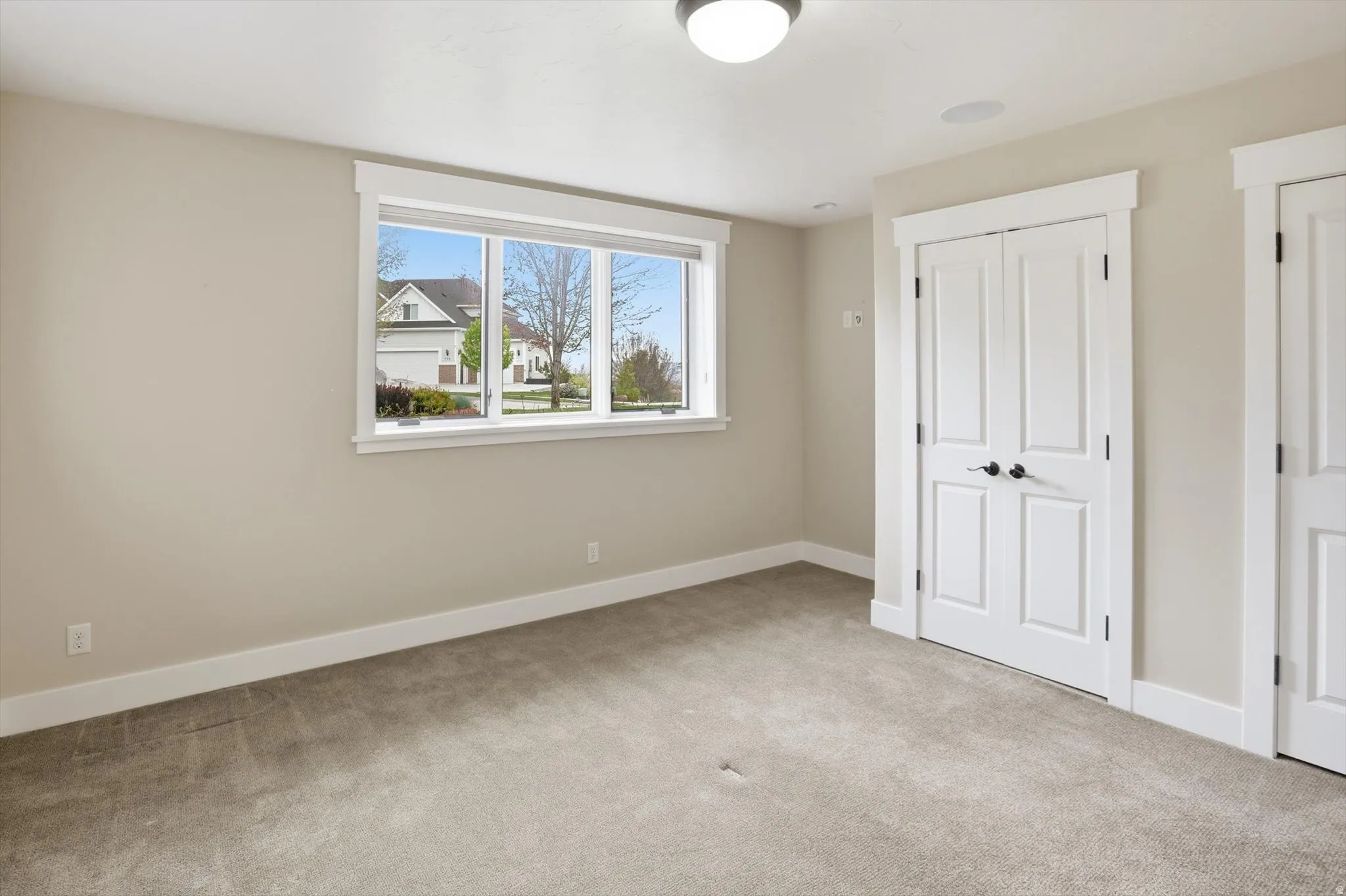 Neutral-toned carpeting paired with light walls and white trim