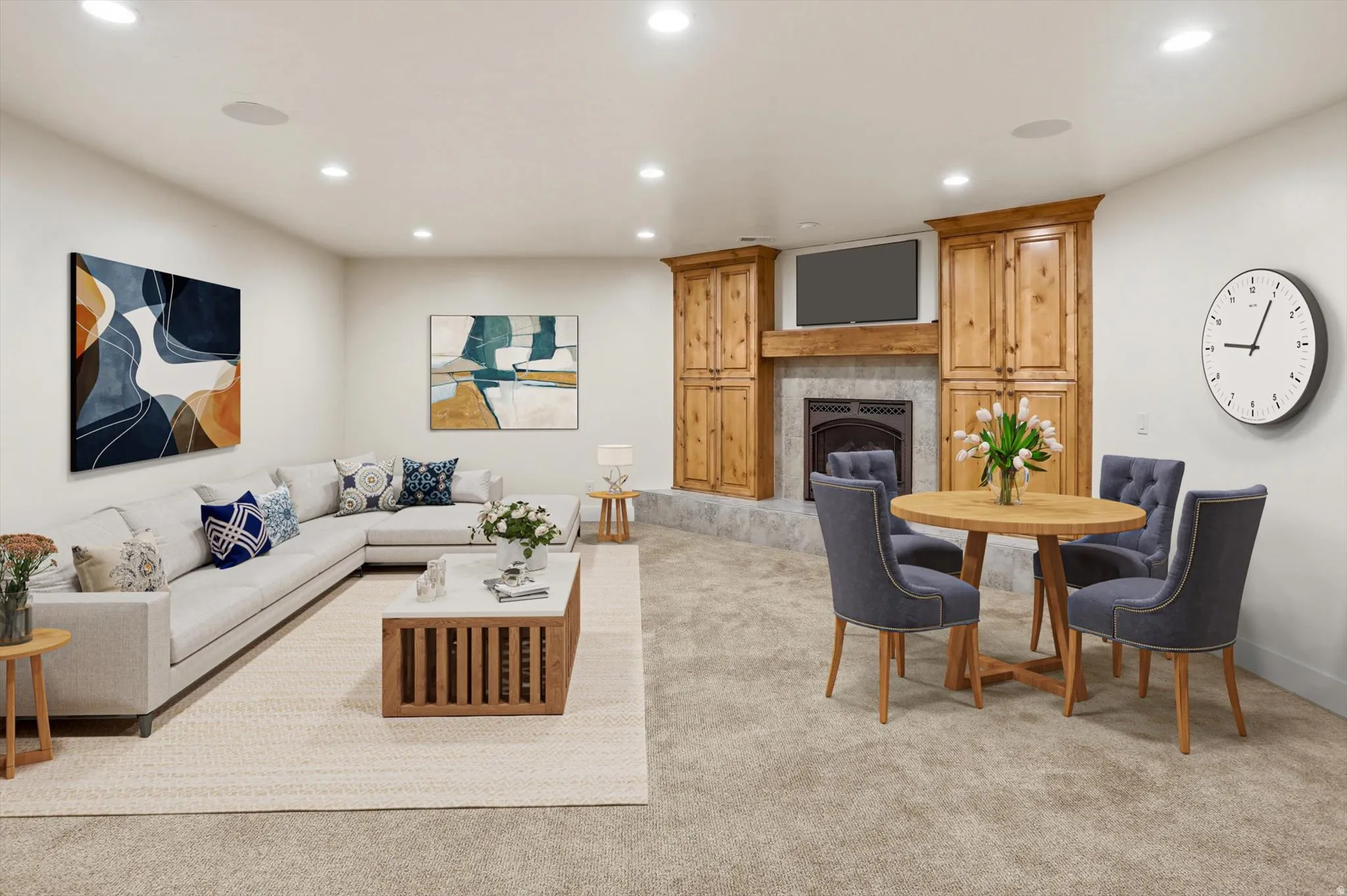 Spacious entertainment room featuring recessed lighting, a built-in fireplace with a stone hearth, and custom wood cabinetry