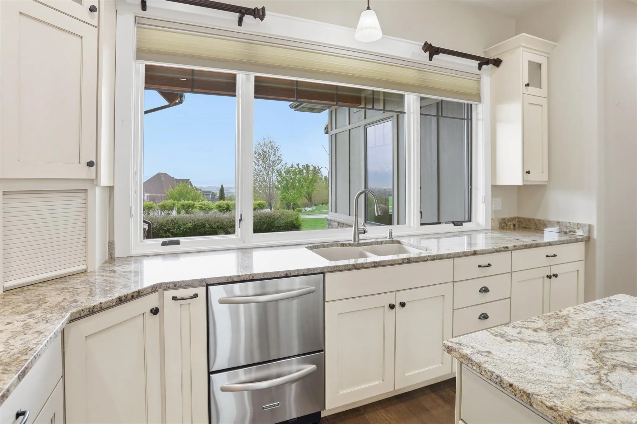 Kitchen featuring a triple window above a double basin sink with a gooseneck faucet