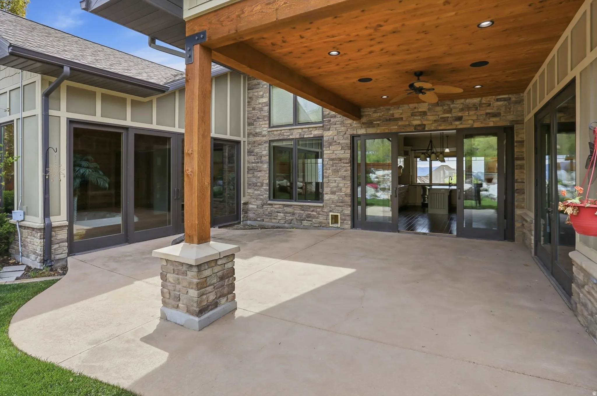 Expansive covered patio featuring a wood-finish ceiling with recessed lighting and a ceiling fan
