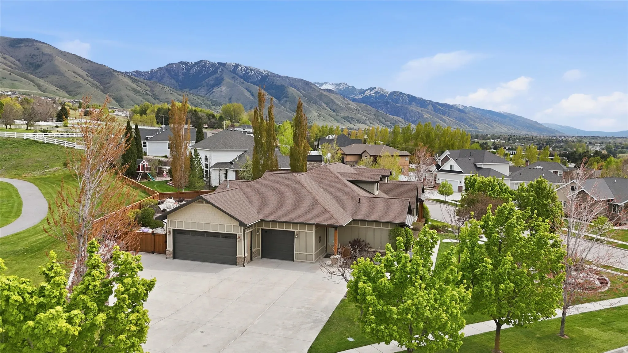 Contemporary home exterior featuring a multi-car garage, concrete driveway, and established landscaping