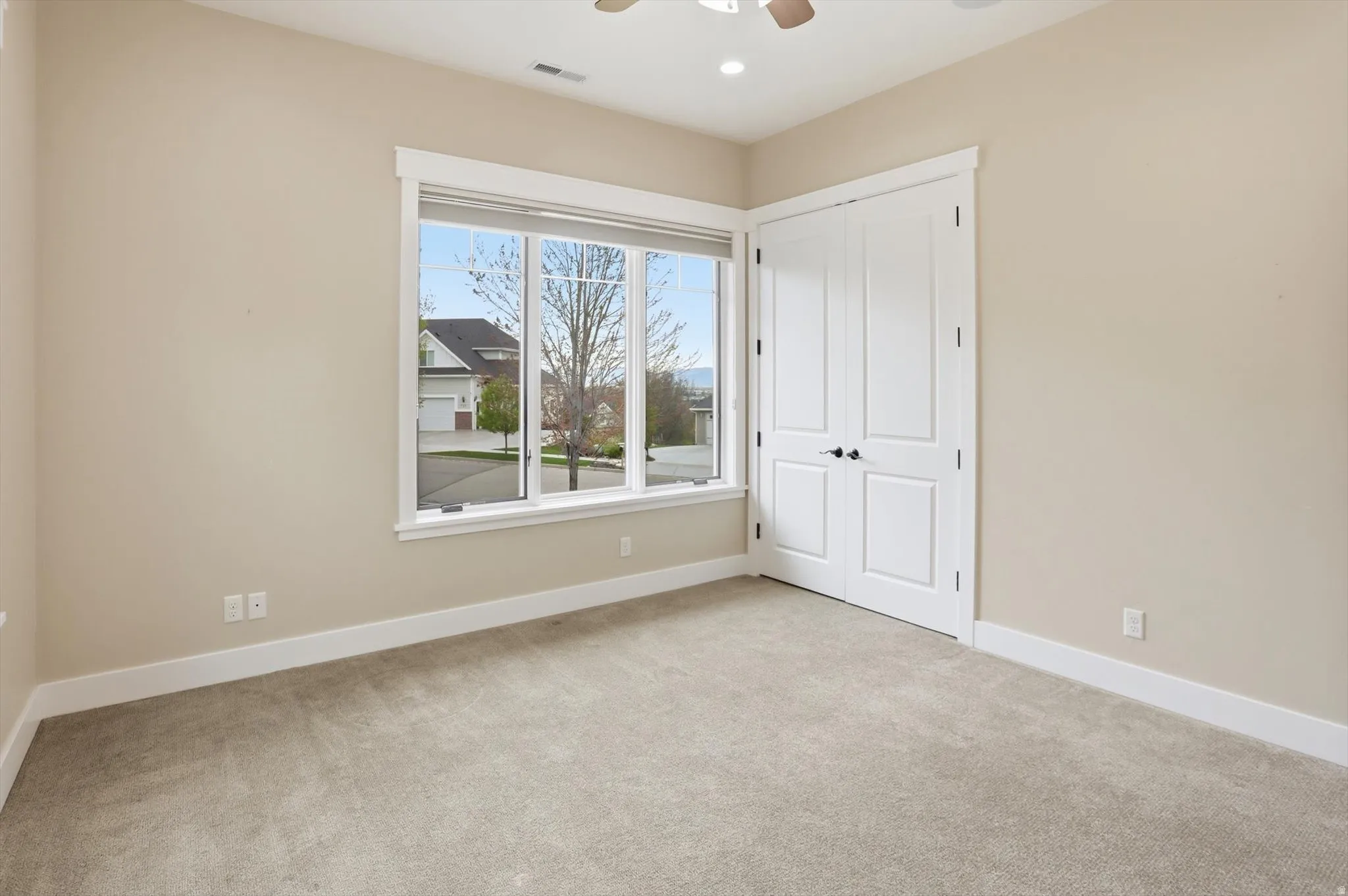 Neutral-toned carpeting and walls complement the white trim and baseboards