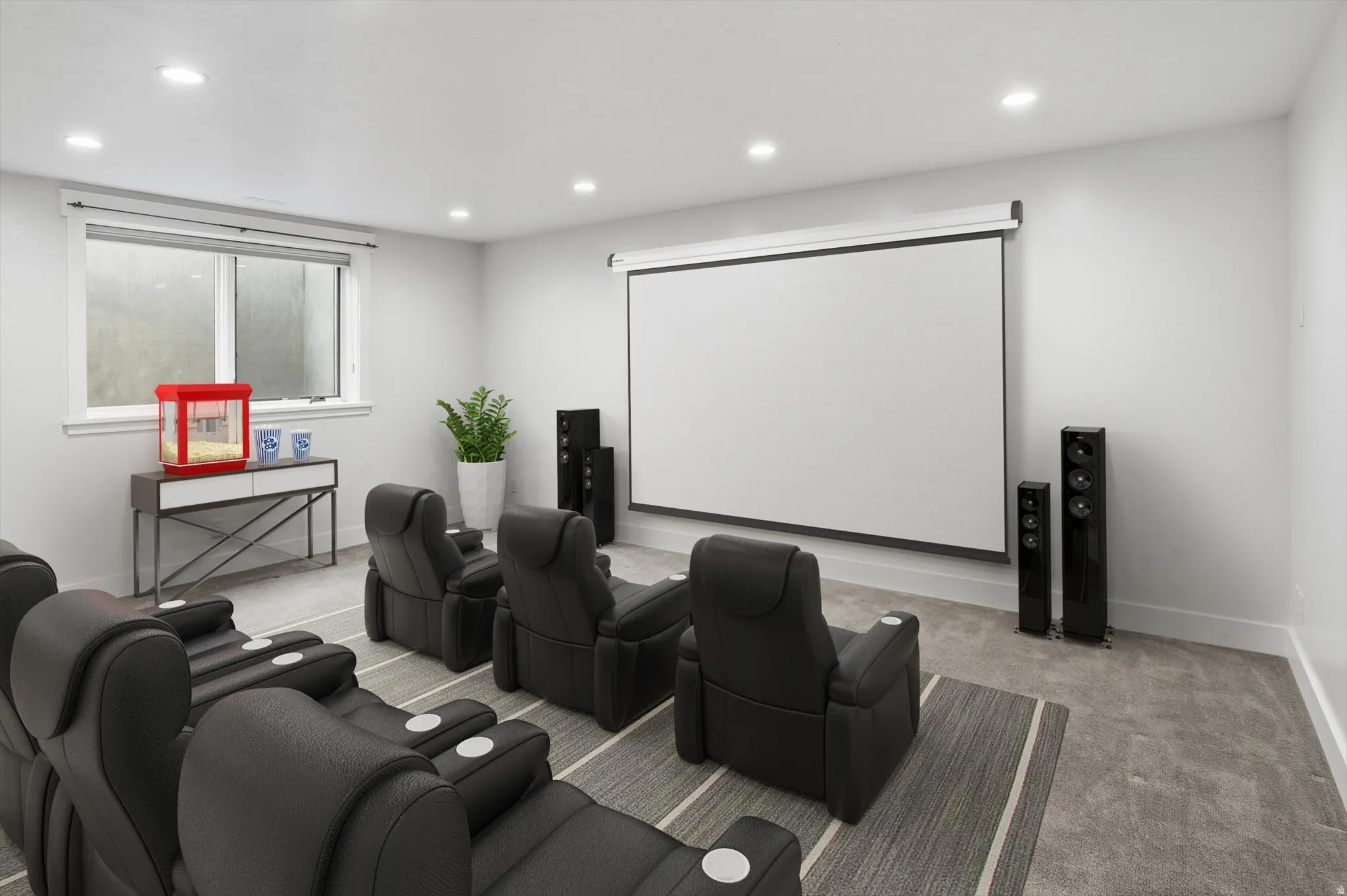 Dedicated media room featuring a large projection screen, recessed lighting, and light gray wall paint