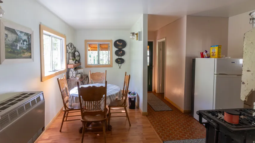 Dining area with wood-finish flooring and two windows featuring wood trim