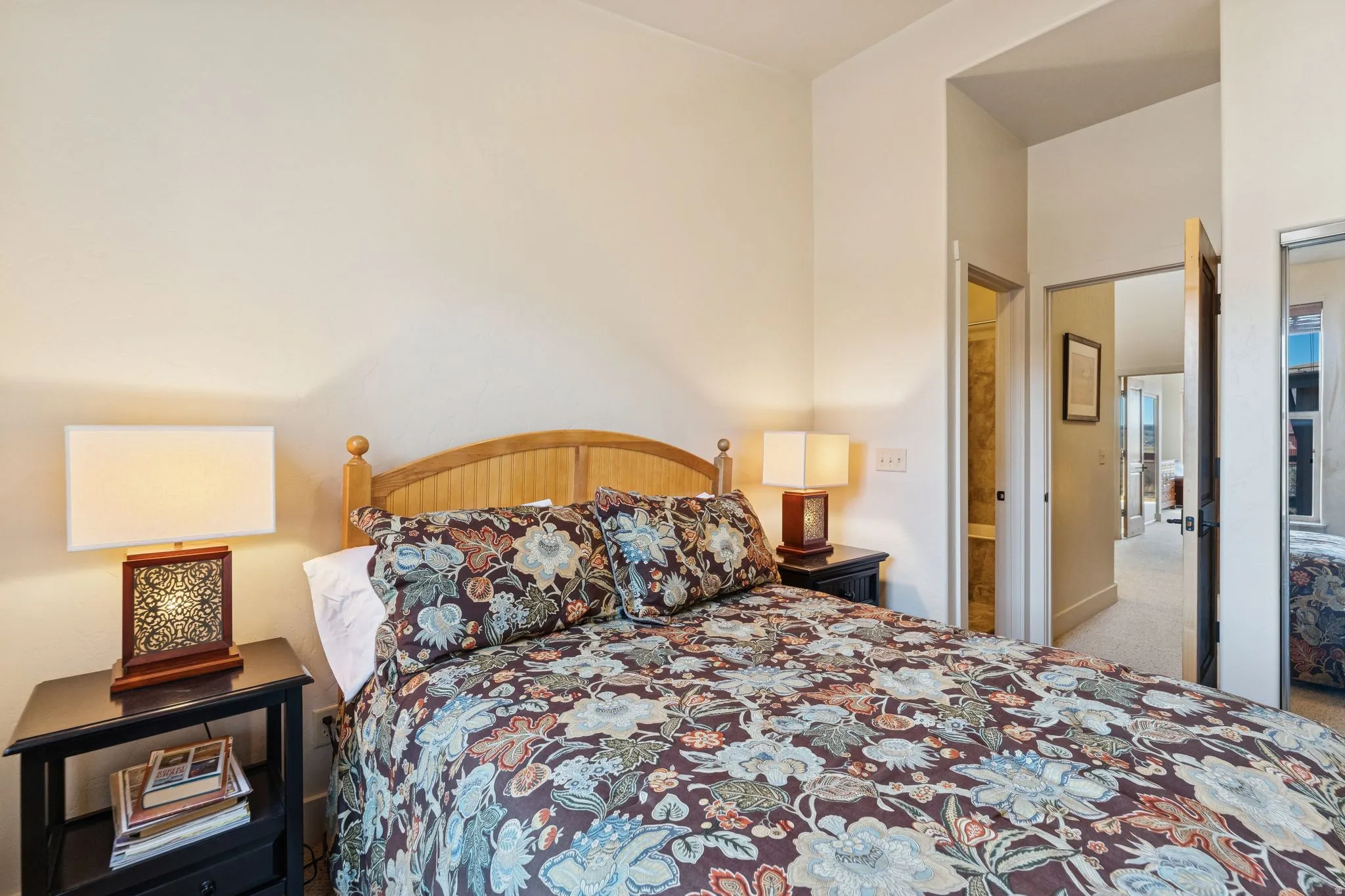 Bedroom featuring light-toned walls, a wooden bed frame, and carpeted flooring